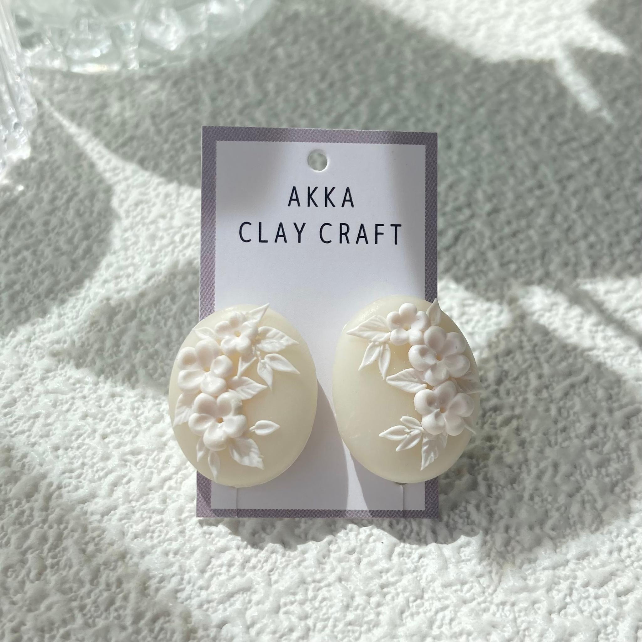 ホワイトオーバル　白花レリーフ耳飾り1枚目の画像